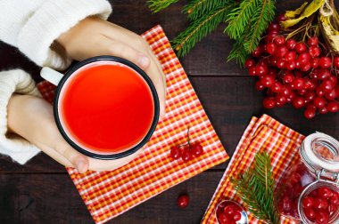 Çocuk elleri ile bir kupa ve sıcak tutan berry çay sıcak. Çay kartopu. Kış şifalı içecek.