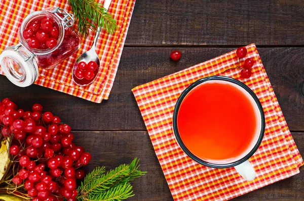 Sıcak berry çay koyu ahşap arka plan üzerinde beyaz bir kupa. Kartopu ile çay.