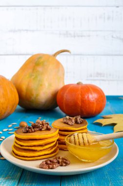 Bal ve mavi ahşap arka plan üzerinde ceviz ile güzel kokulu altın kabak krep. Geleneksel Amerikan yemeği