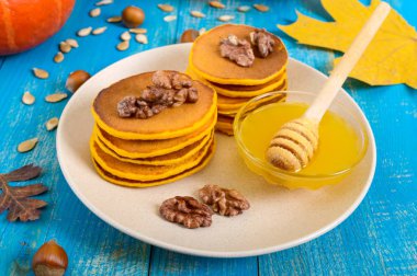 Bal ve mavi ahşap arka plan üzerinde ceviz ile güzel kokulu altın kabak krep. Geleneksel Amerikan yemeği