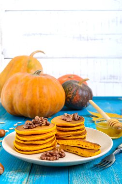 Bal ve mavi ahşap arka plan üzerinde ceviz ile güzel kokulu altın kabak krep. Geleneksel Amerikan yemeği