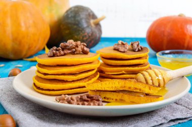Bal ve mavi ahşap arka plan üzerinde ceviz ile güzel kokulu altın kabak krep. Geleneksel Amerikan yemeği