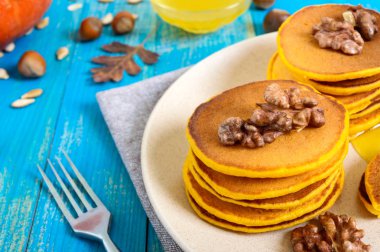 Bal ve mavi ahşap arka plan üzerinde ceviz ile güzel kokulu altın kabak krep. Geleneksel Amerikan yemeği