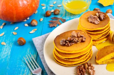 Bal ve mavi ahşap arka plan üzerinde ceviz ile güzel kokulu altın kabak krep. Geleneksel Amerikan yemeği