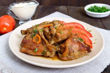 Tavşan parçalar ile seramik tabak içinde koyu ahşap arka plan üzerinde taze domates ihtiva eder. Diyet menüsü.