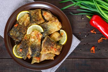 Kızarmış Balık parçalarını (koyu ahşap arka plan üzerinde seramik bir tabakta sazan). Üstten Görünüm.