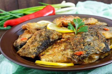 Kızarmış Balık parçalarını (koyu ahşap arka plan üzerinde seramik bir tabakta sazan).