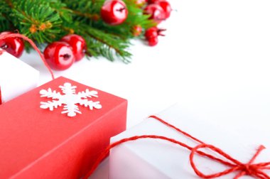 Noel, yeni yıl tema. Kutlama arka plan. Hediyelik kutular, yeşil çam dalları, beyaz üzerine dekoratif kırmızı meyveler. Tebrik kartı. Mutlu Noeller.