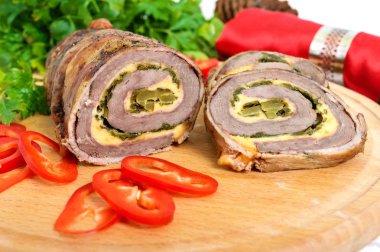 Pastırma Beyaz ahşap zemin üzerinde domates soslu köfte (rulo) peynir, ıspanak, salatalık turşusu ile sarılı. Tatil menüsü.