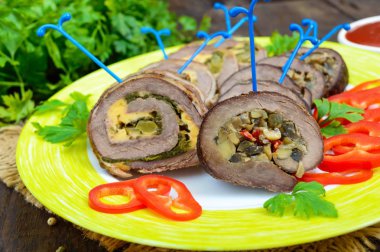 Rulo köfte (rulo) (ıspanak, peynir, mantar), farklı dolguları ile tatlı biber ile seramik plaka üzerinde parçalar halinde kesilmesi. Festival et yemek.