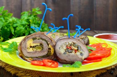 Rulo köfte (rulo) (ıspanak, peynir, mantar), farklı dolguları ile tatlı biber ile seramik plaka üzerinde parçalar halinde kesilmesi. Festival et yemek.