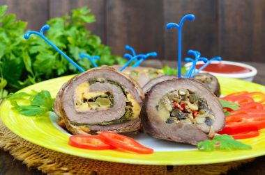 Rulo köfte (rulo) (ıspanak, peynir, mantar), farklı dolguları ile tatlı biber ile seramik plaka üzerinde parçalar halinde kesilmesi. Festival et yemek.