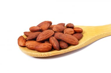 Ahşap kase ve beyaz arka plan üzerinde izole bütün fındık ceviz taneleri.