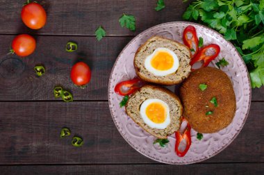 Büyük sulu pirzola koyu ahşap arka plan haşlanmış yumurta ile doldurulmuş. İskoç pirzola. Üstten Görünüm