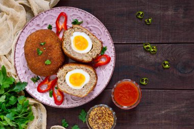 Büyük sulu pirzola koyu ahşap arka plan haşlanmış yumurta ile doldurulmuş. İskoç pirzola. Üstten Görünüm