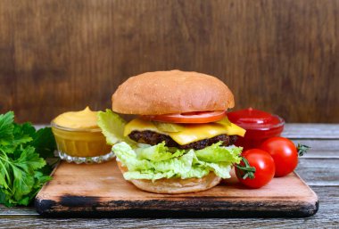 Ahşap arka plan üzerinde sulu hamburger. Fast food. Sokak gıda.
