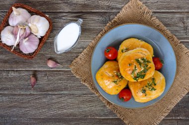 Otlar ve ekşi krema bir ahşap zemin üzerine sarımsak ile yumuşak buns. Üstten Görünüm.