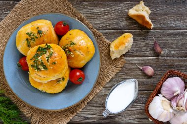 Otlar ve ekşi krema bir ahşap zemin üzerine sarımsak ile yumuşak buns. Üstten Görünüm.