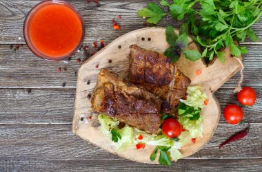 Kızarmış domuz kaburga bir kesme tahtası üzerinde yeşillikleri ile. Üstten Görünüm