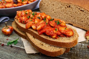 Çavdar ekmeği fasulye ile bir parça. Otlar ve baharatlar tablo ile domates sosu haşlanmış fasulye. Paskalya menü. Vegan yemek.