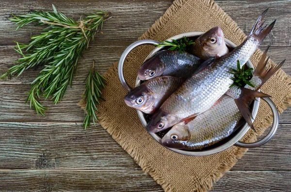 En hög med färsk rå fisk på en trä bakgrund. Ovanifrån. Karp. — Stockfoto