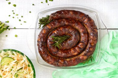 Ev yapımı sosis. Lezzetli bir yüzük Beyaz ahşap bir masa üzerinde ev yapımı sosis pişirdim. Festival çanak. Üstten Görünüm