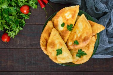 Ahşap bir masa üzerinde sulu altın chebureks. Geleneksel Türk-Moğol çanak. Sokak gıda. Bistro.