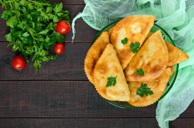 Ahşap bir masa üzerinde sulu altın chebureks. Geleneksel Türk-Moğol çanak. Sokak gıda. Bistro.