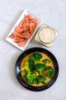 Kaynamış brokoli, karides, çimento kaplı pirinç. Sağlıklı beslenme konsepti. Spor diyeti. Düzgün beslenme için bir takım malzemeler. Sağlıklı bir yaşam tarzı. Uzayı kopyala Üst görünüm.
