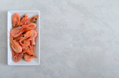 Beton zeminde karides var. Sağlıklı beslenme konsepti. Spor diyeti. Doğru beslenmek için gerekli malzemeler, deniz ürünleri. Sağlıklı bir yaşam tarzı. Uzayı kopyala Üst görünüm