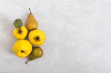 Hafif beton zeminde olgun ayva ve armut meyveleri. Vitamin ve sağlığın kaynağı. Sağlıklı beslenme konsepti. Boşluğu kopyala.