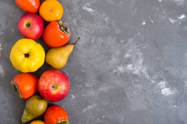 Beton zeminde farklı mevsimsel meyveler. Vitamin ve sağlığın kaynağı. Sağlıklı beslenme konsepti. Boşluğu kopyala.