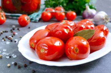 Beyaz tabakta biberli ve sarımsaklı baharatlı domates. Ev yapımı konserve. Sebze turşusu..