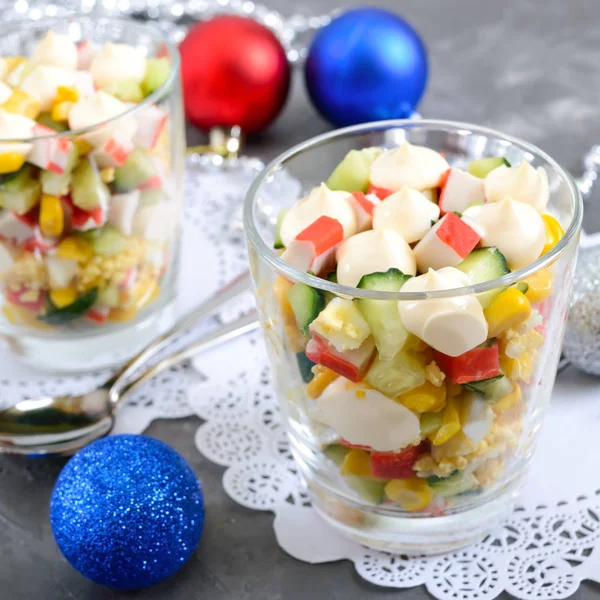 Crab salad. Delicious light salad of crab sticks, corn, fresh cucumbers, eggs in a glass cup. Holiday salad. Dishes for the New Year, Christmas.