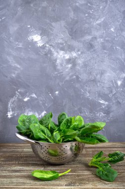 Tahta masadaki bir kasede taze ıspanak yaprakları. Faydalı, lezzetli, düşük kalorili sebzeler. Genç ıspanak filizleri. Keto diyeti. Boşluğu kopyala