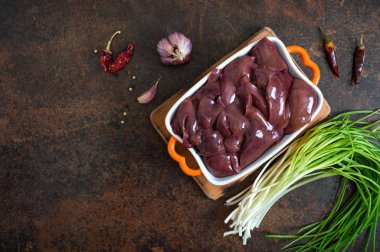 Masadaki kasede çiğ tavuk ciğeri. Offal. Pişirmeye hazır. Üst Manzara. Tabaklar karaciğerden..