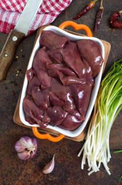 Masadaki kasede çiğ tavuk ciğeri. Offal. Pişirmeye hazır. Üst Manzara. Tabaklar karaciğerden..