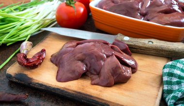 Masadaki kasede çiğ tavuk ciğeri. Offal. Pişirmeye hazır. Tabaklar karaciğerden..
