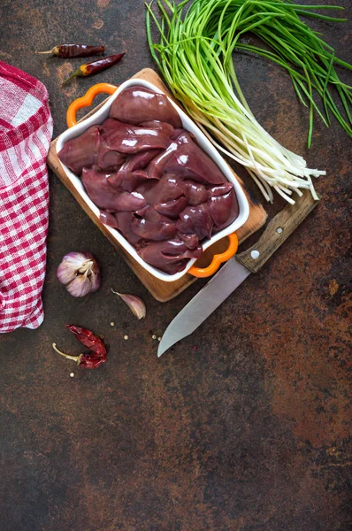 Raw chicken liver in a bowl on the table. Offal. Ready to cook. Top view. Dishes from the liver.