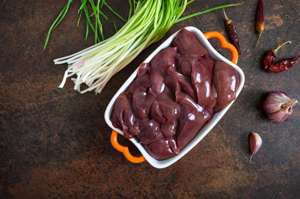 Raw chicken liver in a bowl on the table. Offal. Ready to cook. Top view. Dishes from the liver.