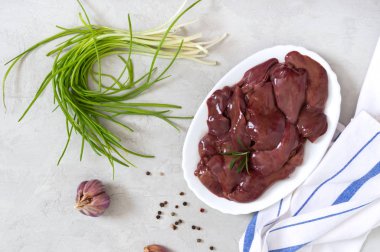 Masadaki kasede çiğ tavuk ciğeri. Offal. Pişirmeye hazır. Üst Manzara. Tabaklar karaciğerden. Üst görünüm