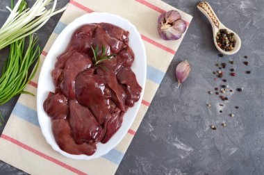 Masadaki kasede çiğ tavuk ciğeri. Offal. Pişirmeye hazır. Üst Manzara. Tabaklar karaciğerden..