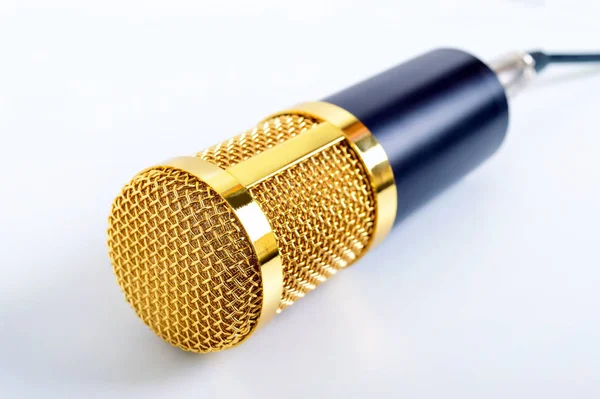 Gold microphone on white background. Musical theme. Condenser microphone. Close up