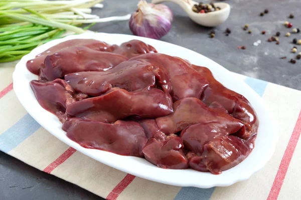 Raw chicken liver in a bowl on the table. Offal. Ready to cook. Dishes from the liver.