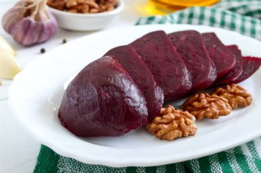 Beyaz bir tabakta haşlanmış pancar dilimleri. Enerjinin kaynağı. Dieta