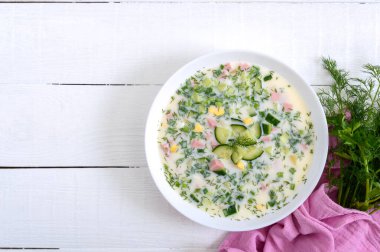 Soğuk yaz çorbası okroshka. Beyaz kasede hafif çorba. Üst görünüm.