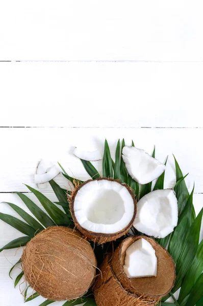 Kokosnuss Ganze Kokosnüsse Schalen Und Grüne Blätter Auf Weißem Holzgrund — Stockfoto