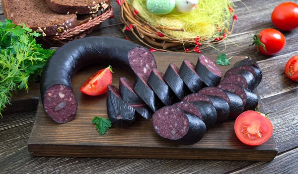 Morsilla - blood sausage. Pieces of Spanish black pudding on a wooden cutting board. Easter menu.