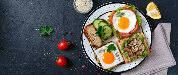 黑色背景上的不同三明治有鳄梨味的健康开胃菜 快吃早餐 健康饮食的概念 适当的营养 顶部视图 — 图库照片