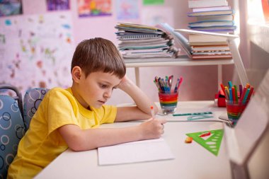 Ödev yapan çocuk. Evde öğrenme, kendini karantina konsepti. Koronavirüs salgını. Kendini izole etme, ev karantinası. Evde uzaklık öğrenimi.